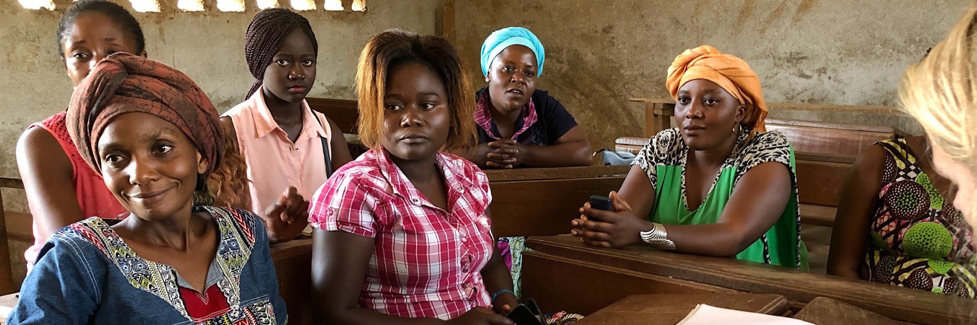 A person correcting and other ladies sitting next to it.
